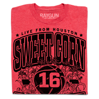 A folded heather red t-shirt with black ink text that reads "Live from Houston: The Sweet Corn 16. IA vs NE. Iowa, Nebraska 2026." In the center of the shirt is a basketball with the number 16 on it, Iowa to the left, Nebraska to the right, and corn growing behind it.