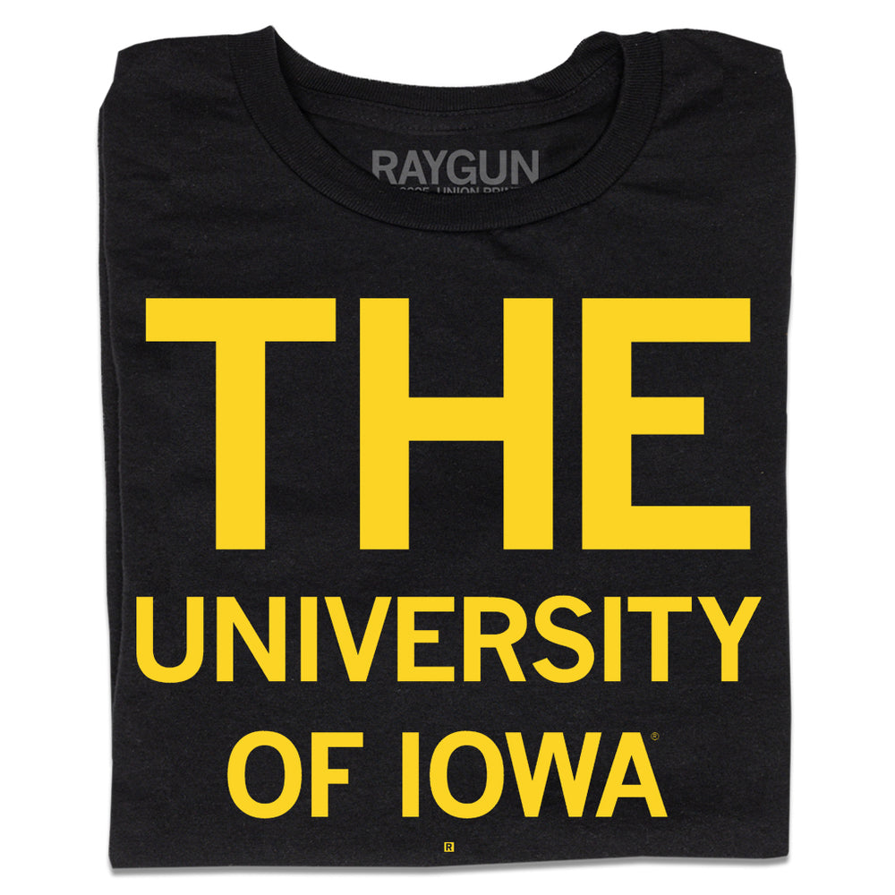 A folded black t-shirt with yellow ink that says, "THE" in huge print at the top with "UNIVERSITY OF IOWA" below.