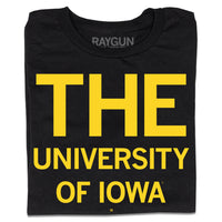 A folded black t-shirt with yellow ink that says, "THE" in huge print at the top with "UNIVERSITY OF IOWA" below.