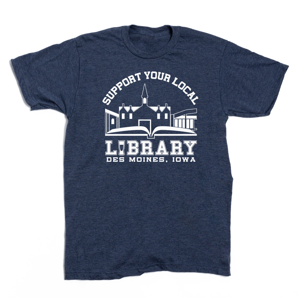 Dark blue RAYGUN t-shirt featuring a white graphic of an open book and a building silhouette with the text: Support Your Local Library Des Moines, Iowa.