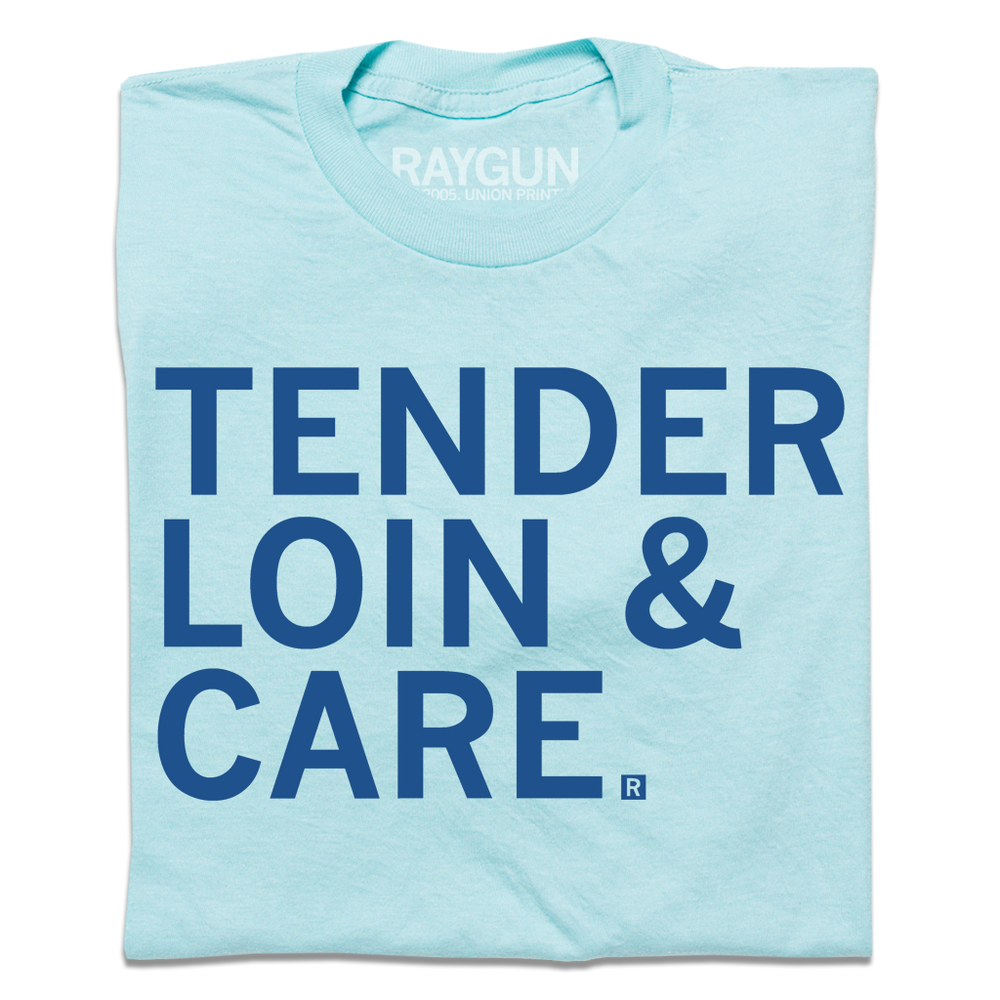A folded pastel blue shirt with royal blue text that says, "TENDER LOIN & CARE."