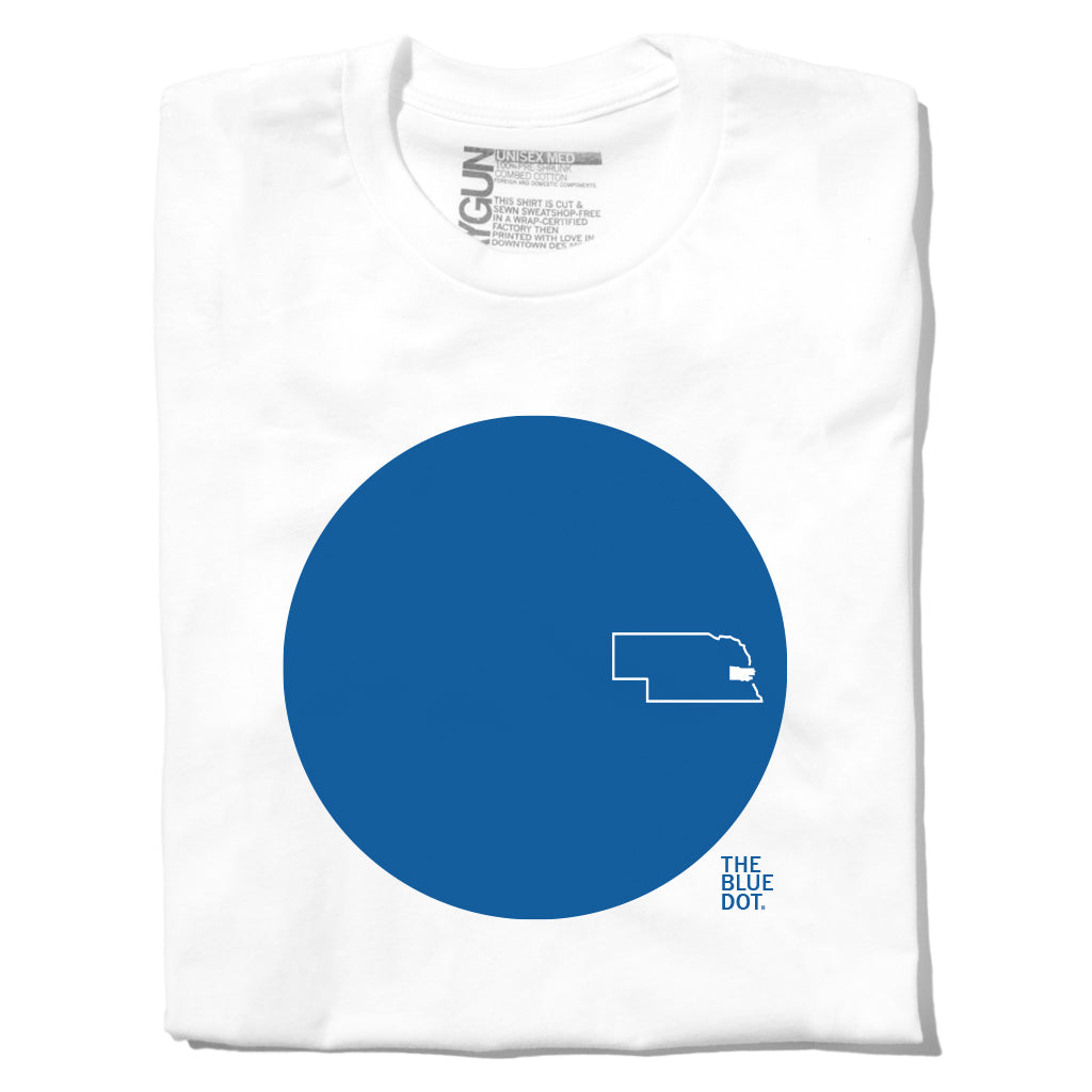 White union made t-shirt featuring a blue circle graphic with a white outline of Nebraska and the text THE BLUE DOT.