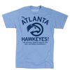 A heather light blue t-shirt with navy ink that reads "The ATLANTA HAWKEYES! The Official Sports Team Of The Vast Left-Wing Conspiracy!" With a bird logo in the center.