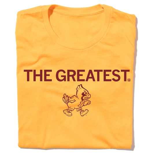 A folded gold t-shirt with centered cardinal print that says, "THE GREATEST" above a vintage Cy Iowa State logo of Cy angrily walking to the right.