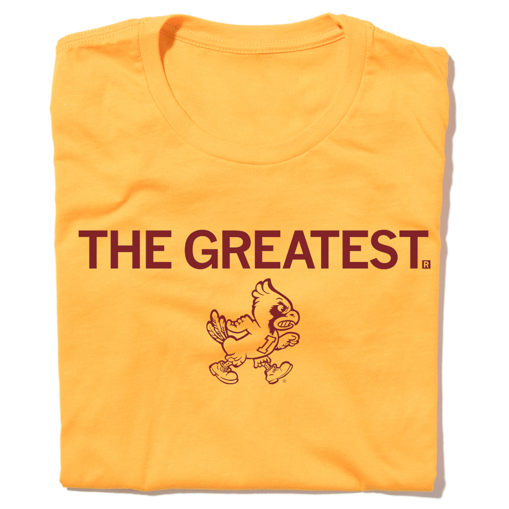 A folded gold t-shirt with centered cardinal print that says, "THE GREATEST" above a vintage Cy Iowa State logo of Cy angrily walking to the right.