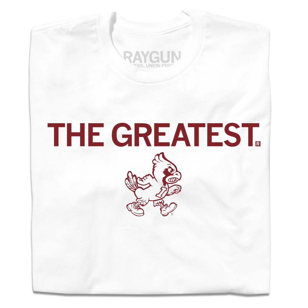 A folded white t-shirt with cardinal print text that says, "THE GREATEST" above a vintage Cy Iowa State logo of Cy walking to the right.
