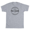 Heather grey t-shirt featuring a circular logo for the Nook Indie Bookstore in Cedar Falls, IA, with the text Est. 2023 and an illustration of stacked books.