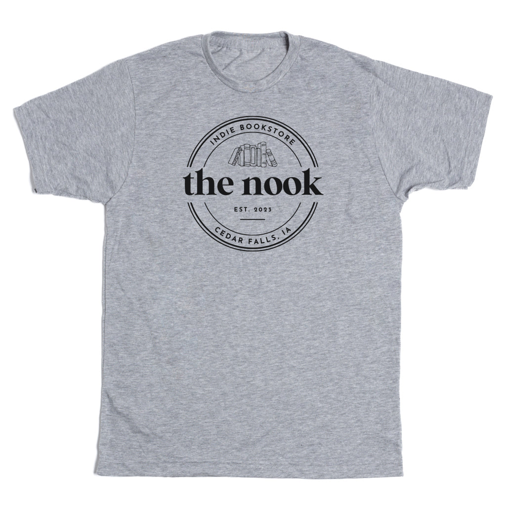 Heather grey t-shirt featuring a circular logo for the Nook Indie Bookstore in Cedar Falls, IA, with the text Est. 2023 and an illustration of stacked books.
