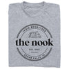 Heather grey t-shirt featuring a circular logo for The Nook, a Cedar Falls, IA indie bookstore, with the text Est. 2023 above an illustration of a row of books.