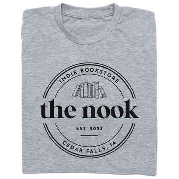 Heather grey t-shirt featuring a circular logo for The Nook, a Cedar Falls, IA indie bookstore, with the text Est. 2023 above an illustration of a row of books.