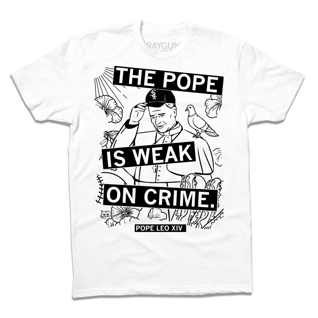 A white RAYGUN t-shirt featuring a line-art illustration of a man in a papal robe and baseball cap, with the text THE POPE IS WEAK ON CRIME and POPE LEO XIV.
