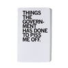 A union-printed white notebook with the black text THINGS THE GOVERNMENT HAS DONE TO PISS ME OFF printed on the cover.