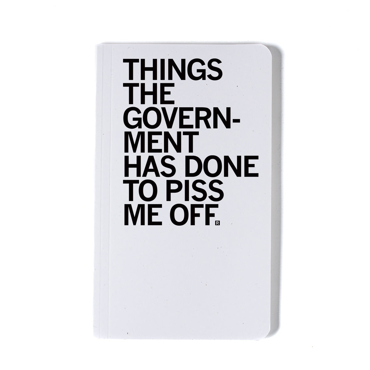 A union-printed white notebook with the black text THINGS THE GOVERNMENT HAS DONE TO PISS ME OFF printed on the cover.