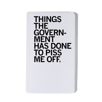 A union-printed white notebook with the black text THINGS THE GOVERNMENT HAS DONE TO PISS ME OFF printed on the cover.