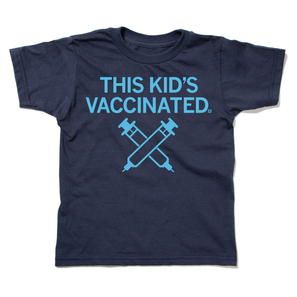 A navy youth t-shirt with bright blue ink that says, "This Kid's Vaccinated" above an illustration of two syringes crossing each other.