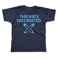 A navy youth t-shirt with bright blue ink that says, "This Kid's Vaccinated" above an illustration of two syringes crossing each other.