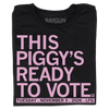 Folded black t-shirt with light pink ink that says, "This piggy's ready to vote. Tuesday, November 3rd 2026. LFG!"