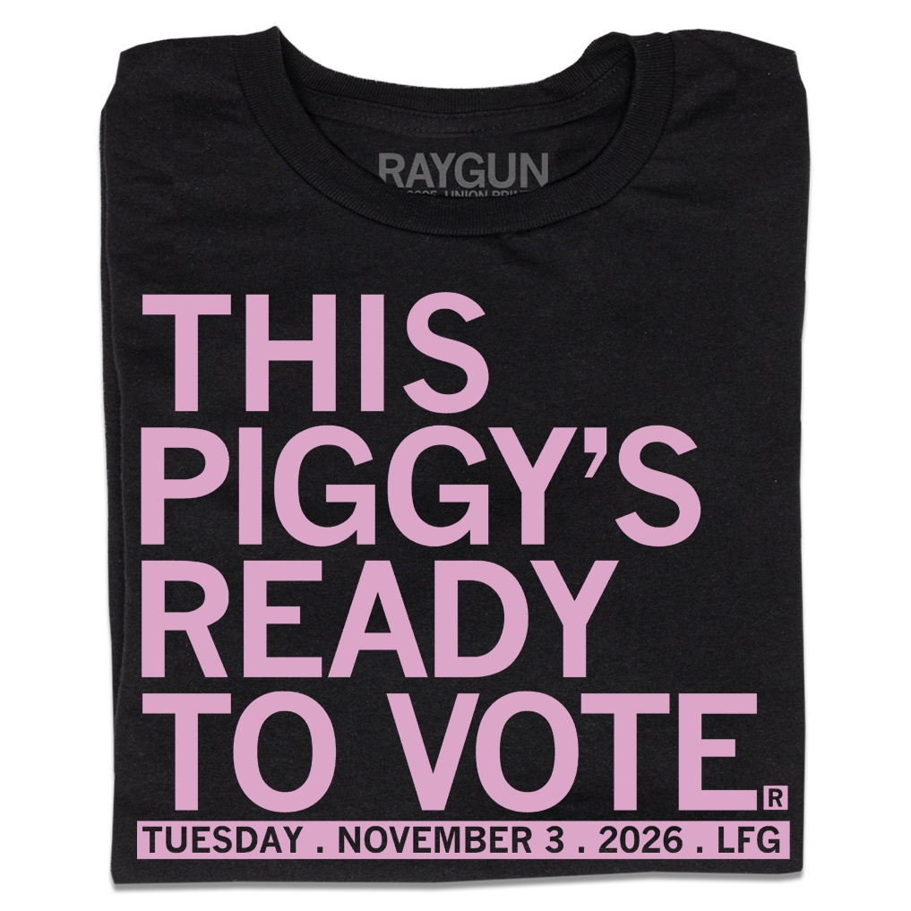 Folded black t-shirt with light pink ink that says, "This piggy's ready to vote. Tuesday, November 3rd 2026. LFG!"