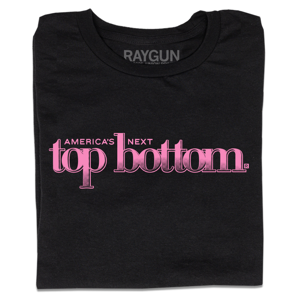 A folded black t-shirt with pink ink that reads 