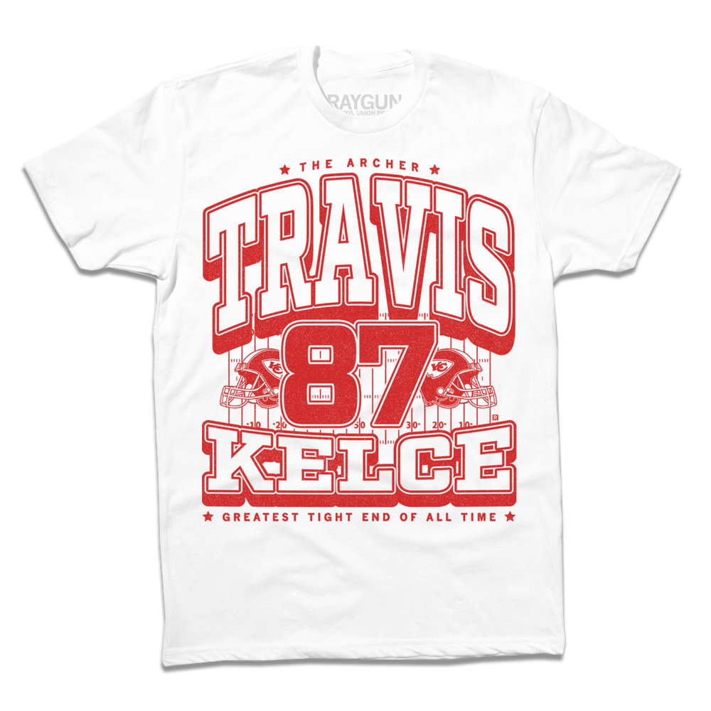 A white shirt with bright red ink that reads "The Archer. Travis Kelce. The Greatest Tight End Of All Time" over an illustration of a football field  with the number 87 and a football helmet on either side.