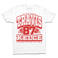 A white shirt with bright red ink that reads "The Archer. Travis Kelce. The Greatest Tight End Of All Time" over an illustration of a football field  with the number 87 and a football helmet on either side.