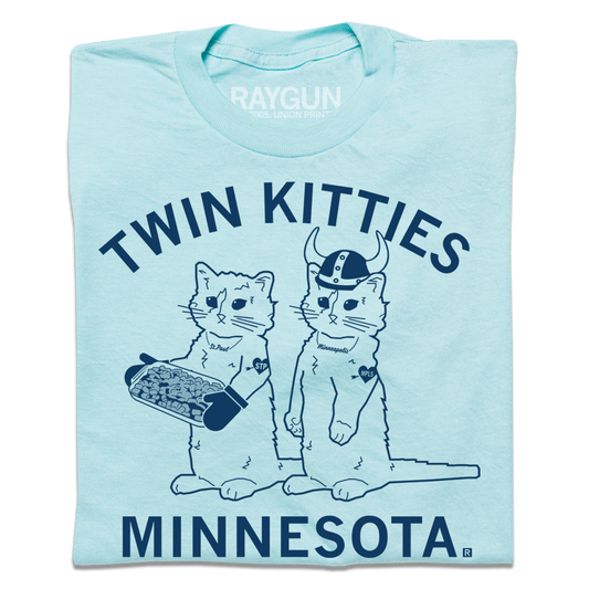Heather Purist Blue t-shirt featuring two cats labeled St. Paul and Minneapolis, with TWIN KITTIES written above and MINNESOTA below.