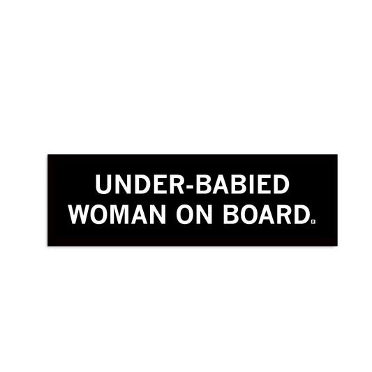 A black bumper sticker with centered, stacked white text that reads "Under-babied woman on board"