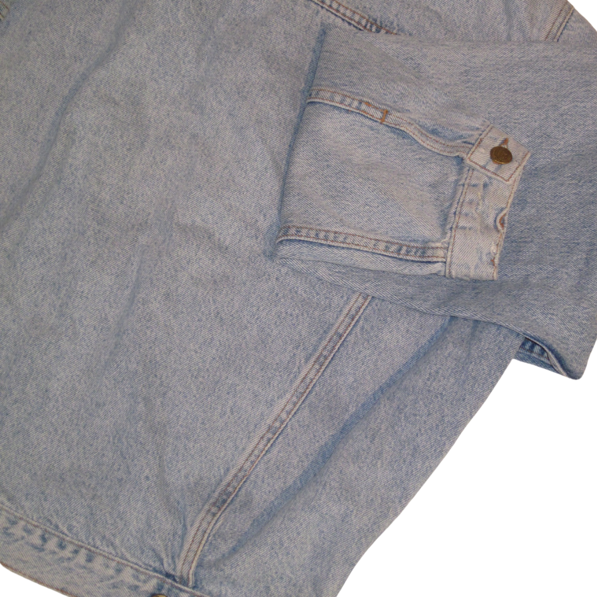 Vintage denim jacket sleeve in a light wash with a buttoned cuff.