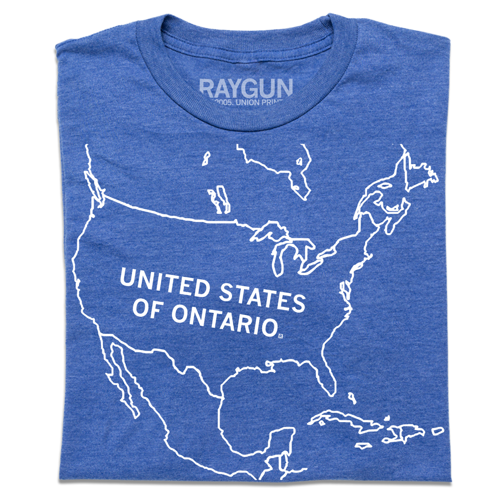 A folded heather blue t-shirt with a white ink outline of North America with "UNITED STATES OF ONTARIO" printed inside the USA.