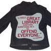 Dark wash denim jacket featuring a light blue graphic on the back with the text, A TRULY GREAT LIBRARY CONTAINS SOMETHING IN IT TO OFFEND EVERYONE. - Jo Godwin.