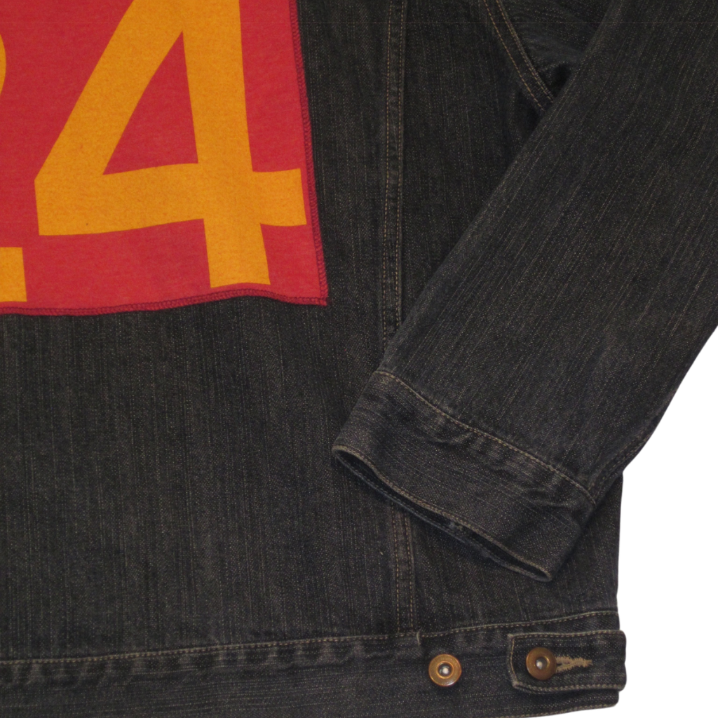 Vintage dark denim jacket with a red patch on the back featuring a large yellow number four.
