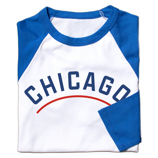 A folded white baseball tee with blue 3/4 sleeves and a blue collar. 