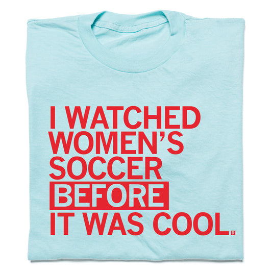 Light blue RAYGUN t-shirt with red text that reads, I WATCHED WOMENS SOCCER BEFORE IT WAS COOL.