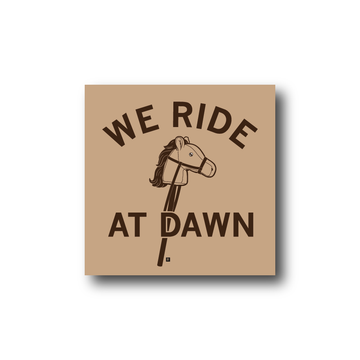 Vinyl sticker featuring an illustration of a hobby horse with the text WE RIDE AT DAWN.