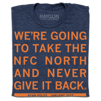 a folded heather navy t-shirt with orange ink text that reads "We're going to take the NFC North and never give it back"