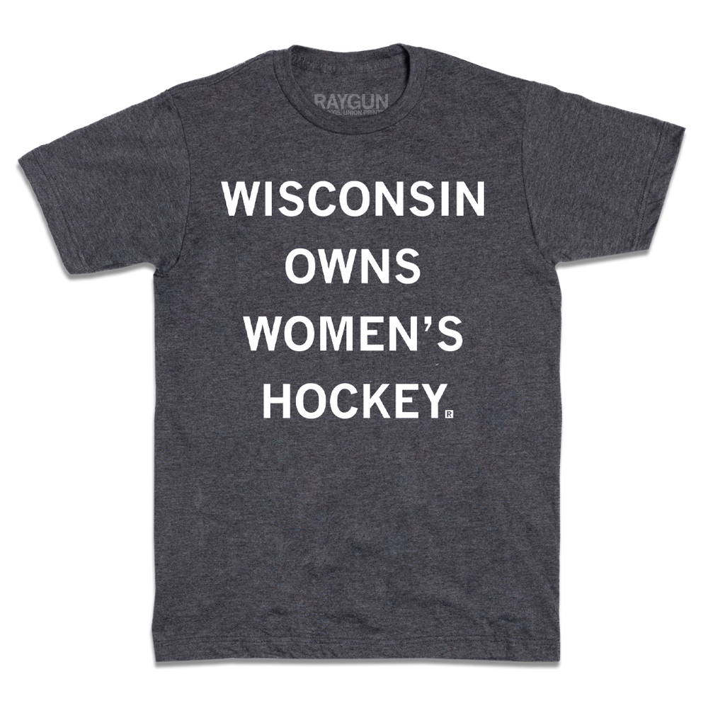A charcoal t-shirt with centered white ink text that reads "Wisconsin owns women's hockey."