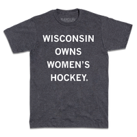 A charcoal t-shirt with centered white ink text that reads "Wisconsin owns women's hockey."