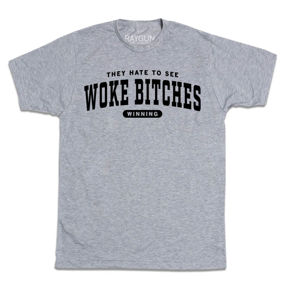 Heather grey tee with black ink text that reads 
"They hate to see 
woke bitches
winning"