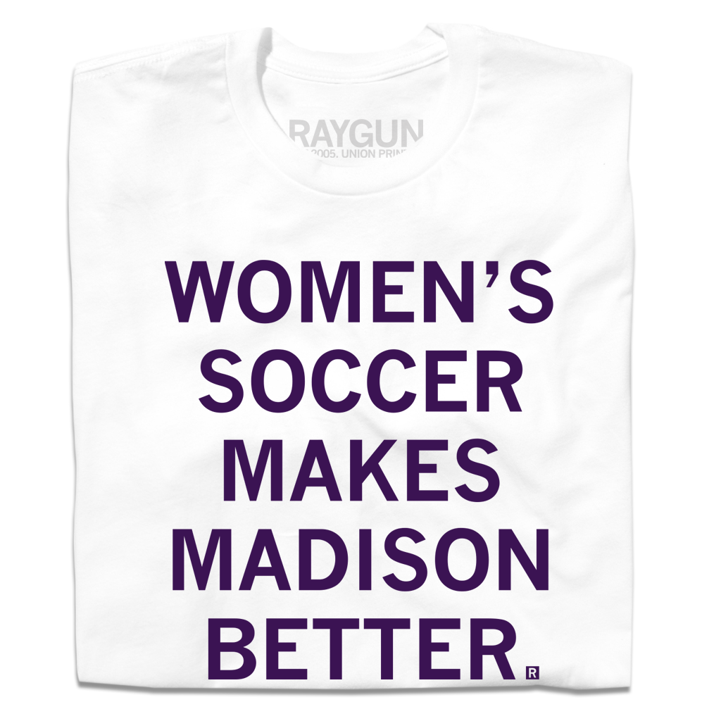 A folded white t-shirt with centered purple ink that says, "Women's soccer makes Madison better."