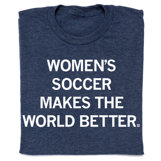 A folded heather denim RAYGUN t-shirt with the white text WOMENS SOCCER MAKES THE WORLD BETTER.