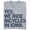 Folded heather grey t-shirt with left-aligned navy ink that says, "YES, WE RIDE BICYCLES IN IOWA."