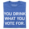 A folded heather royal blue t-shirt with centered white text that says, "You Drink What You Vote For" in all caps.
