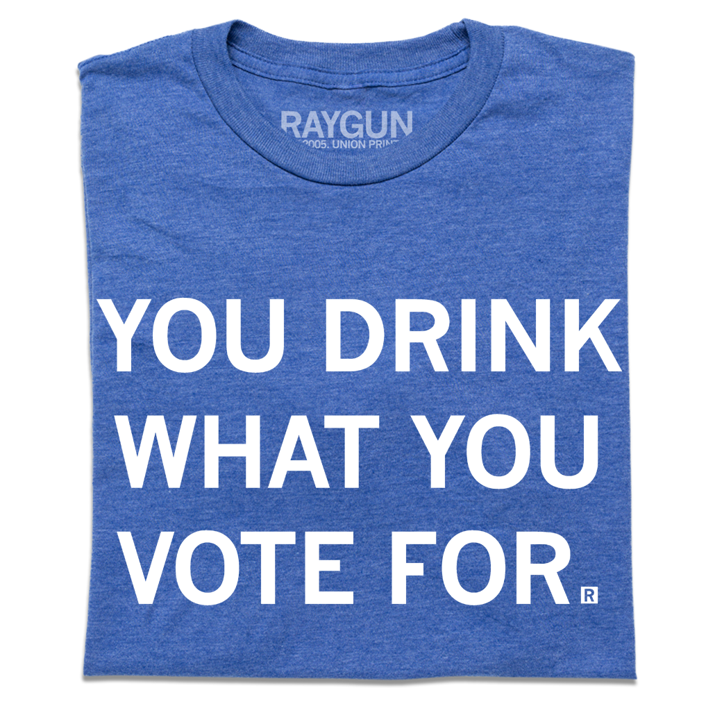 A folded heather royal blue t-shirt with centered white text that says, "You Drink What You Vote For" in all caps.