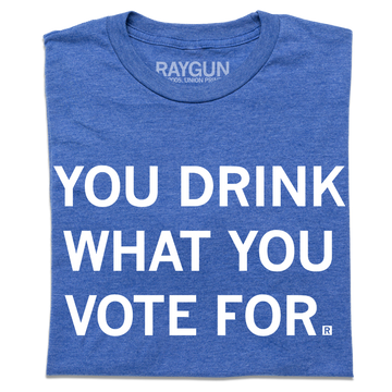 A folded heather royal blue t-shirt with centered white text that says, "You Drink What You Vote For" in all caps.