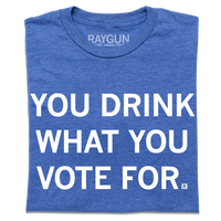 A folded heather royal blue t-shirt with centered white text that says, "You Drink What You Vote For" in all caps.