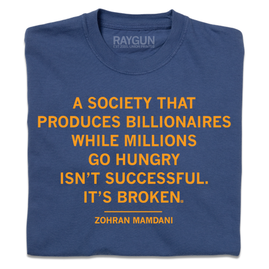A blue comfort colors shirt with the Zohran Mamdani quote "A society that produces billionaires while millions go hungry isn't successful. It's broken" printed in orange ink.