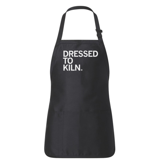 A black, union-made full-length apron featuring an adjustable neck strap and the text DRESSED TO KILN. printed in white.