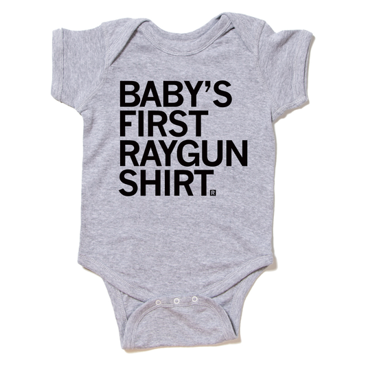 Heather gray baby onesie with the text BABYS FIRST RAYGUN SHIRT printed in black.