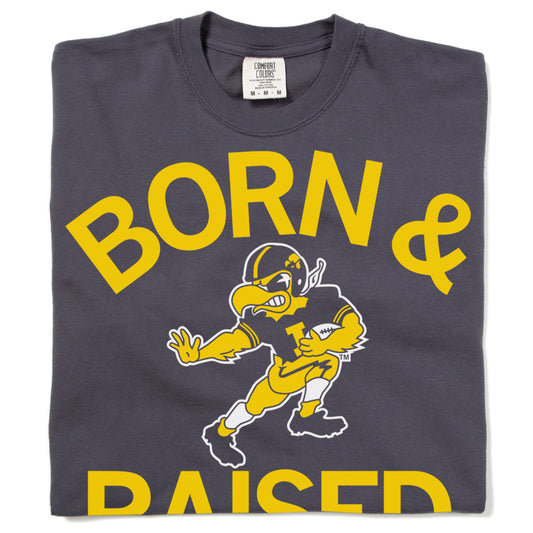 Charcoal gray union-made Raygun t-shirt with the yellow text BORN & RAISED and an illustration of a football-playing bird mascot in the center.