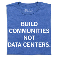 A folded heather royal blue t-shirt with centered white text that says, "Build Communities Not Data Centers."